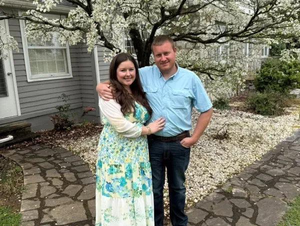 Dr. Jacob Harris and his wife, Dr. Brittany Harris, standing in front of a flowering tree
